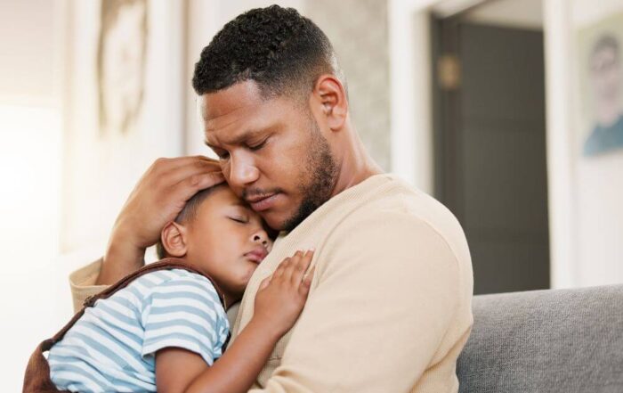 A young boy asleep on his father's chest